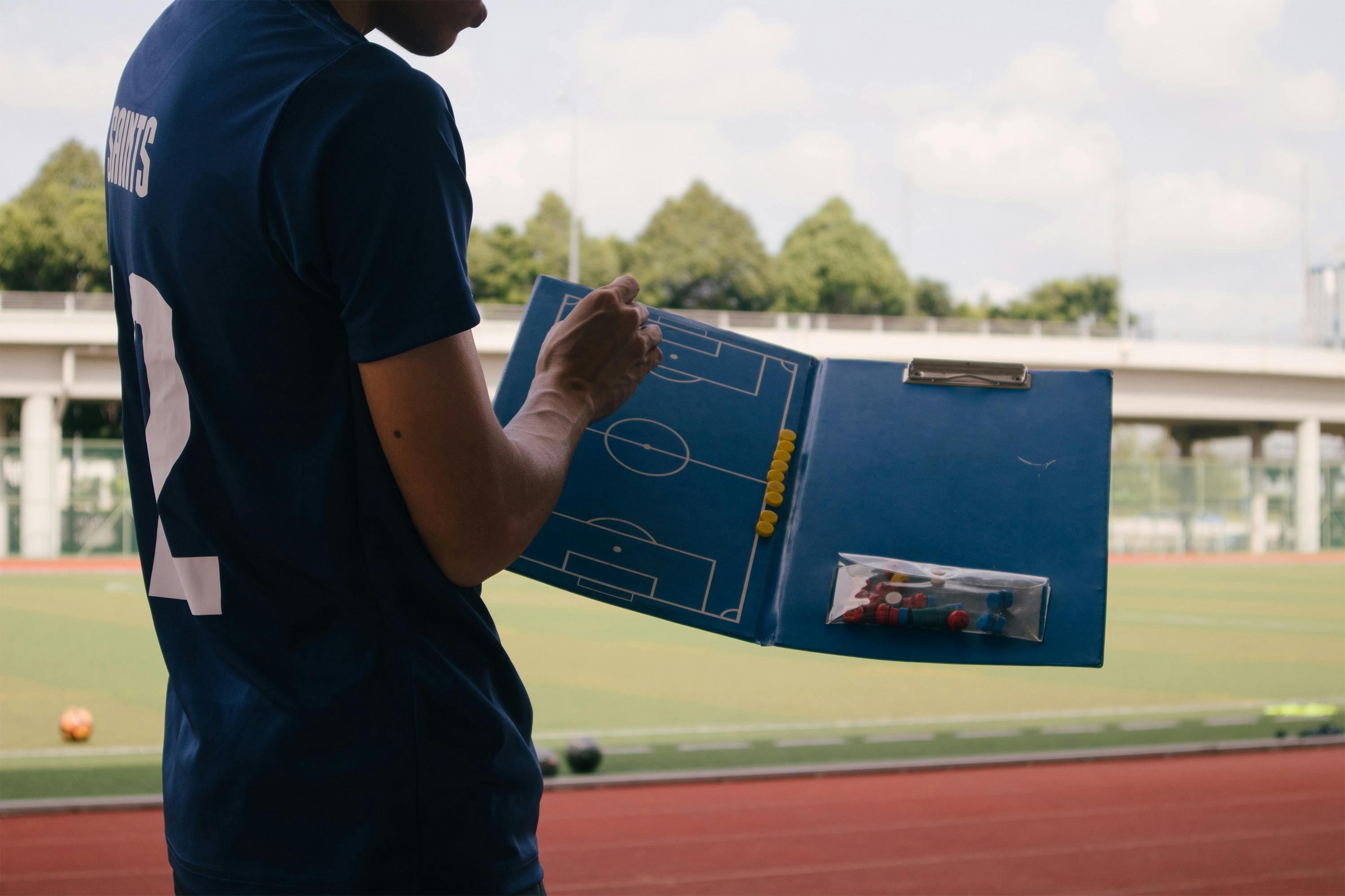 A man holding a soccer pitch playbook